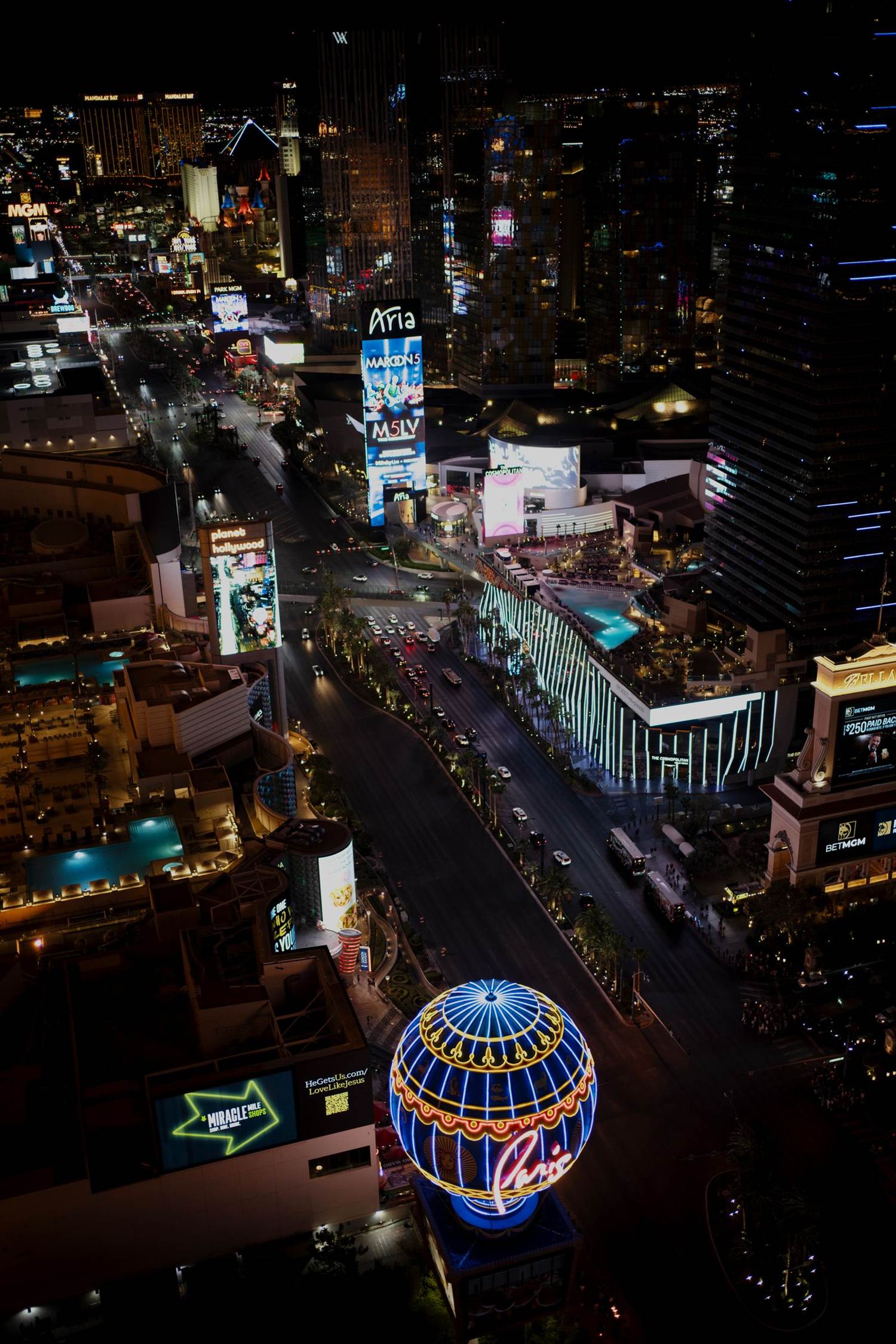 Aerial night view down the Strip with the Paris balloon in the foreground