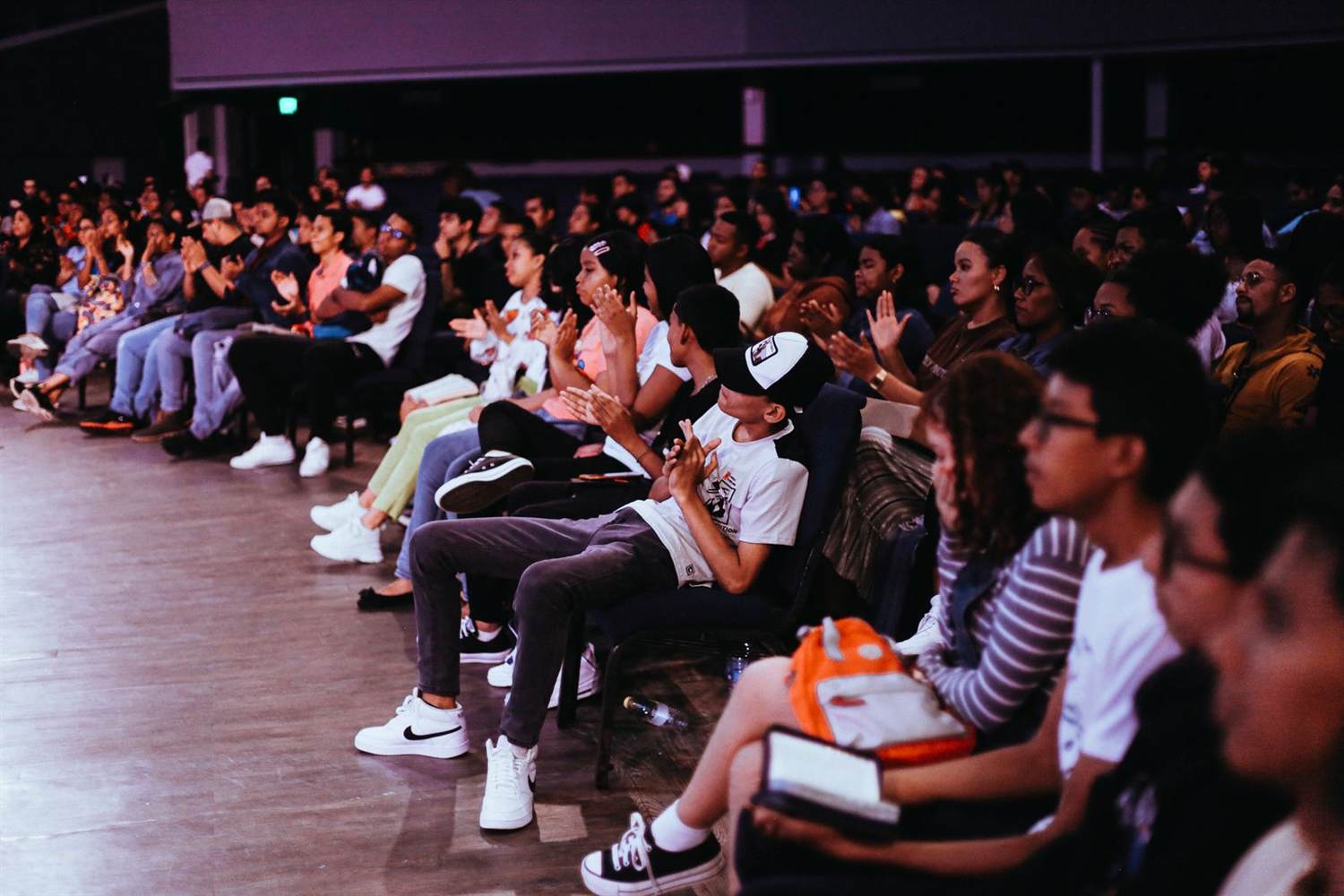 A seated audience applauding at a conference session