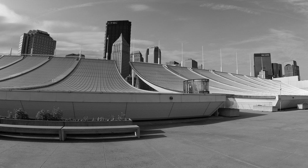 The curved suspension roof of the David L. Lawrence Convention Center with the downtown Pittsburgh skyline behind it