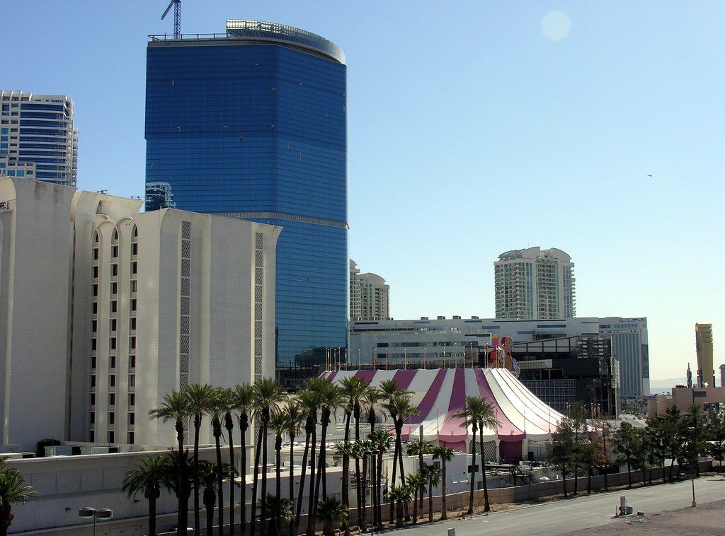 The blue-glass Fontainebleau Las Vegas tower rising behind palm trees on the north Strip, with a construction crane still on its roof