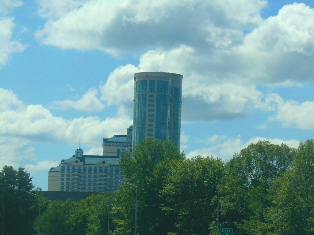 The round glass Fox Tower and the Grand Pequot Tower at Foxwoods Resort Casino rising above the trees