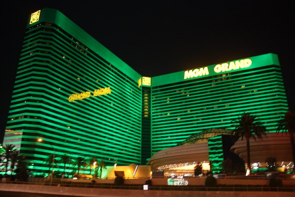 The green-glass towers of MGM Grand Las Vegas lit up at night, with the MGM Grand sign on the north tower