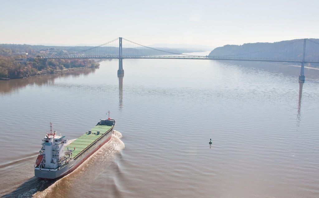 The cargo ship Flinterdijk on the Hudson River below the Mid-Hudson Bridge at Poughkeepsie, with autumn trees on the shore