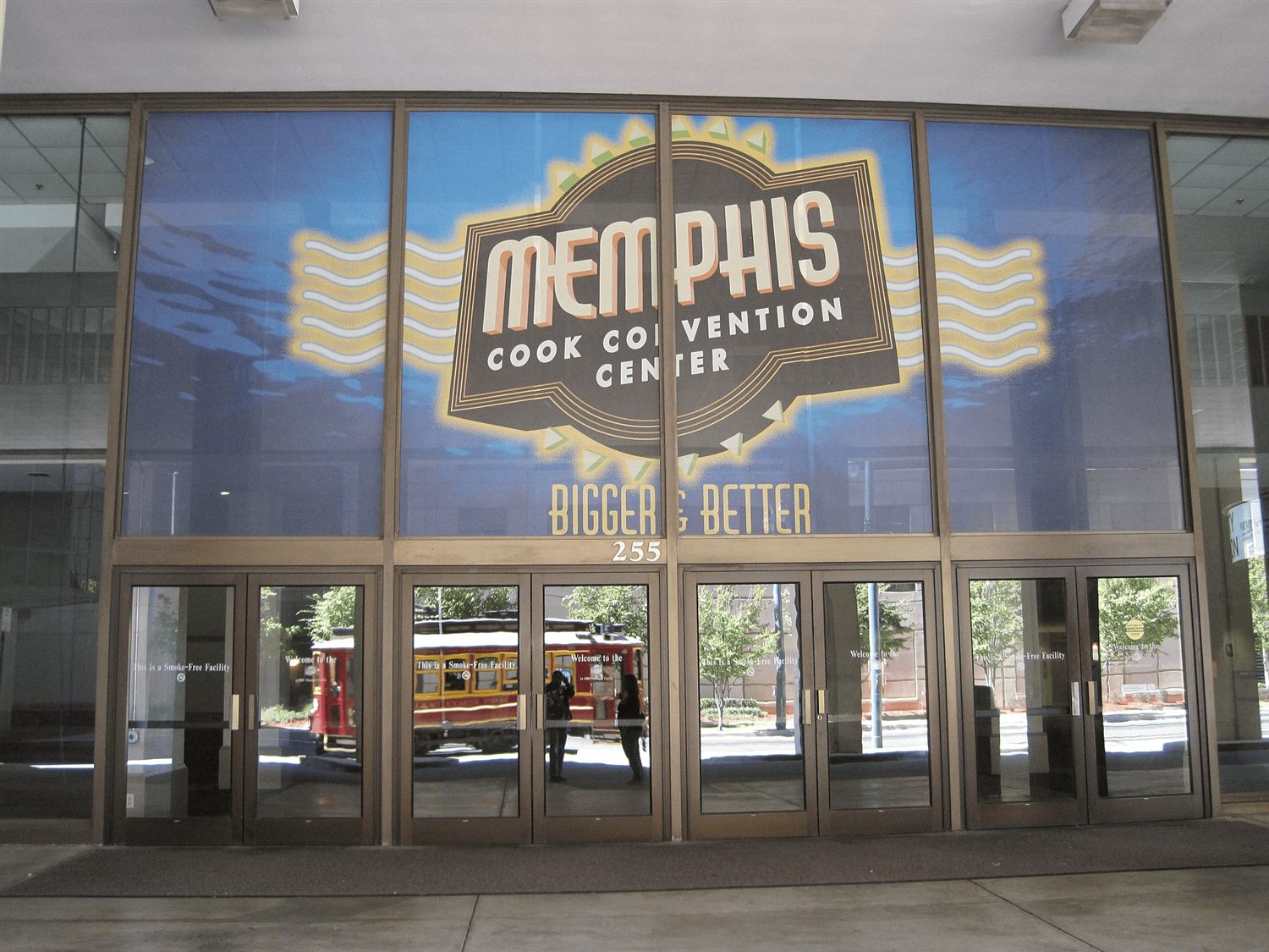 The Main Street entrance at 255 N Main in 2010, when the building was still the Memphis Cook Convention Center, with a trolley reflected in the doors
