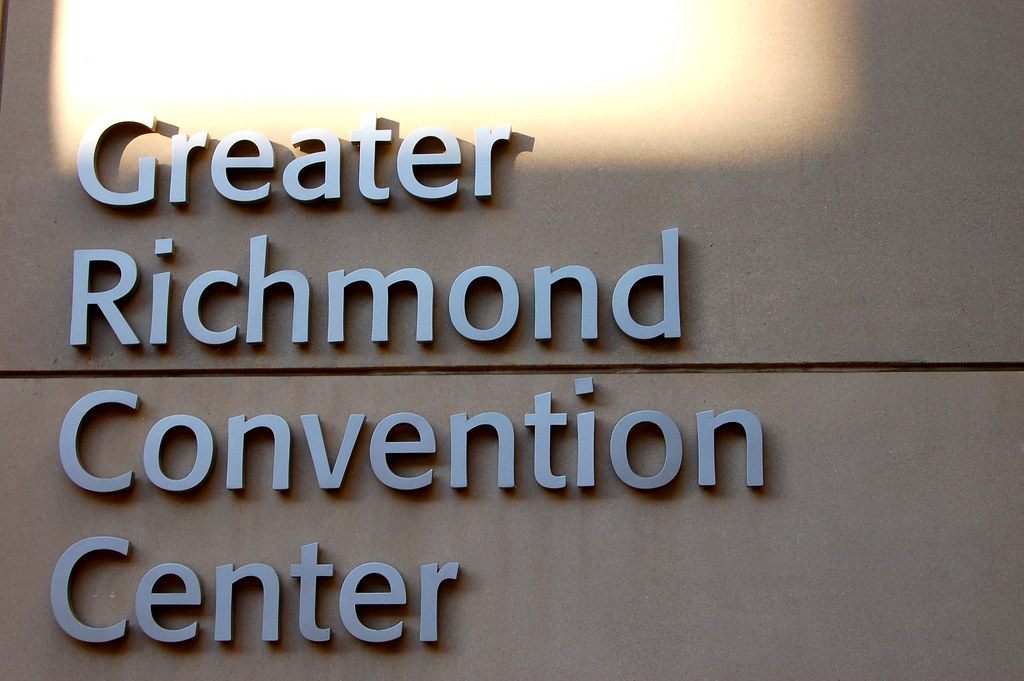 Brushed-metal letters spelling Greater Richmond Convention Center on the stone wall of the building, lit by late-afternoon sun