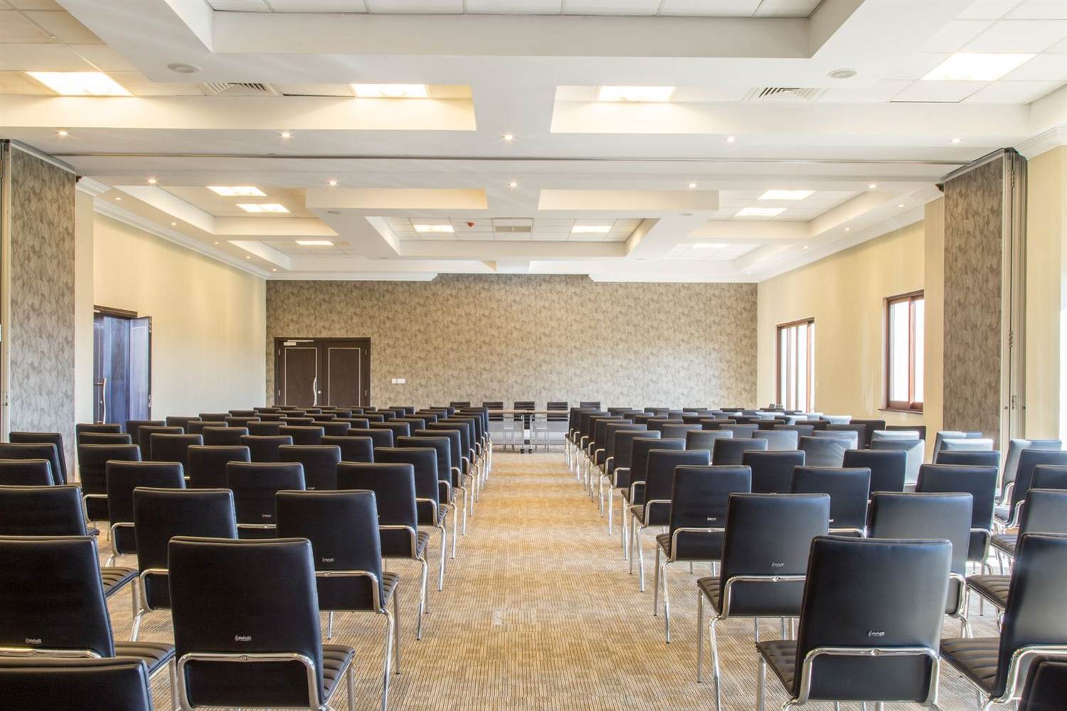 An empty meeting room set up theater-style with rows of chairs