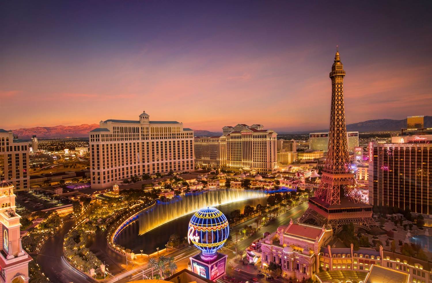 Aerial view of the Las Vegas Strip at dusk with the Bellagio lake, Caesars Palace and the High Roller