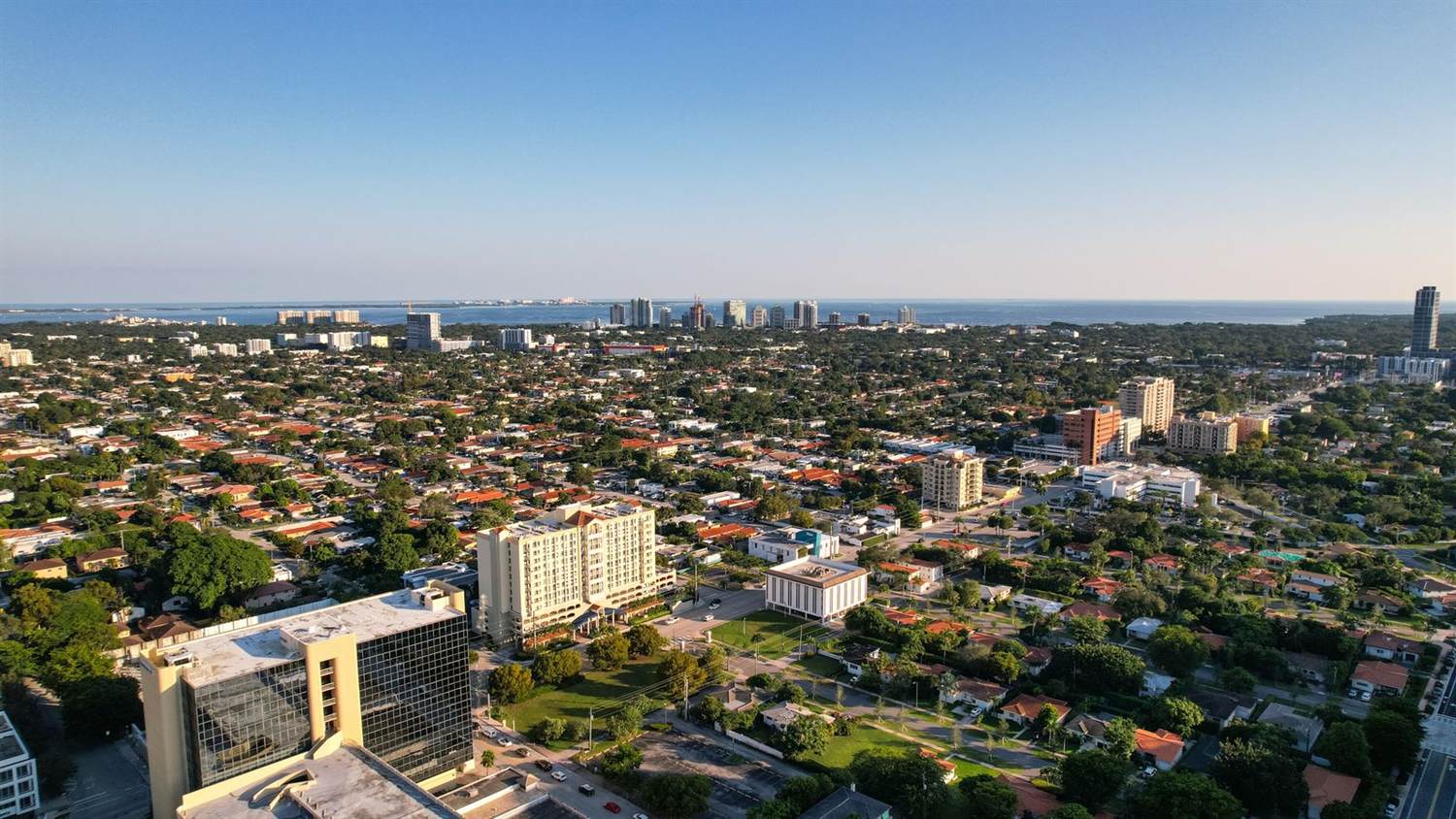 An aerial view of Central Florida rooftops and a distant coastal skyline