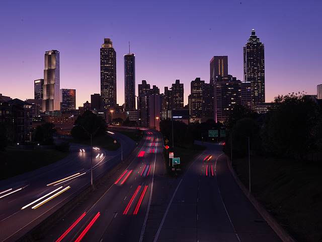 Dusk view of the Atlanta skyline from the Jackson Street Bridge, with light trails from traffic