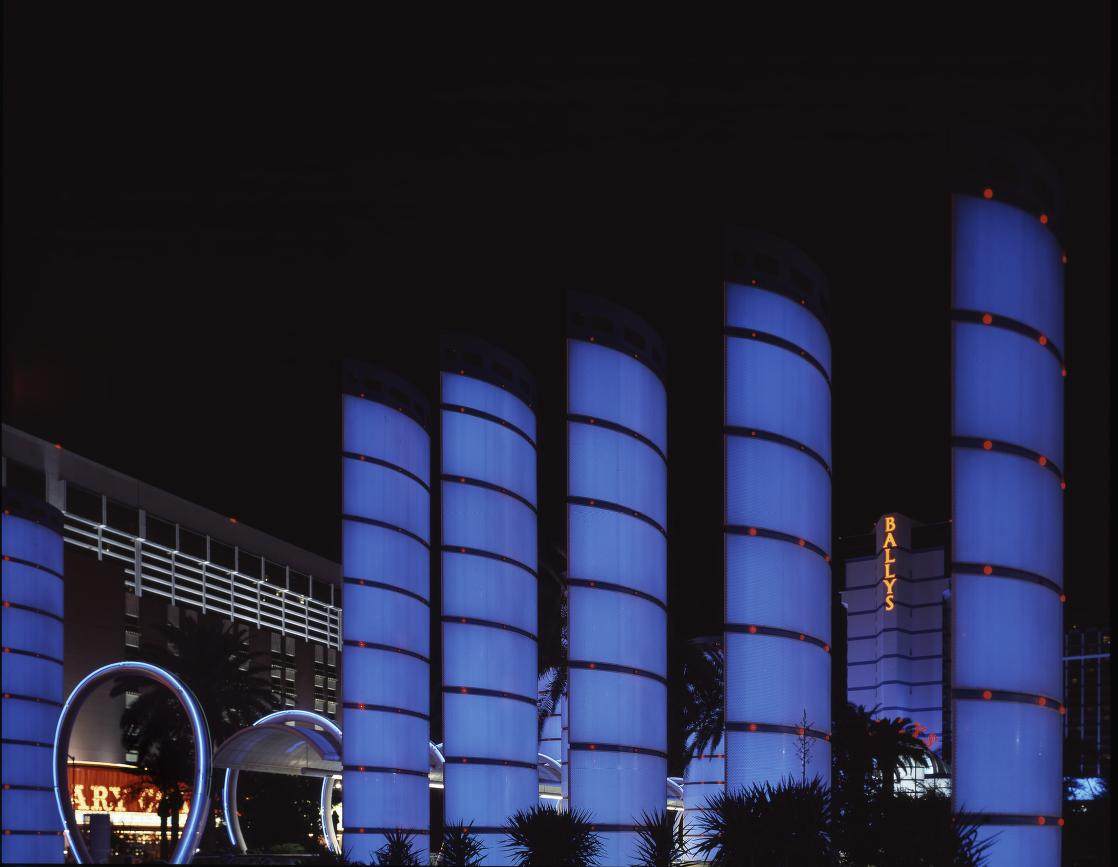 Blue-lit columns and neon arches at the Bally's entrance on the Strip at night