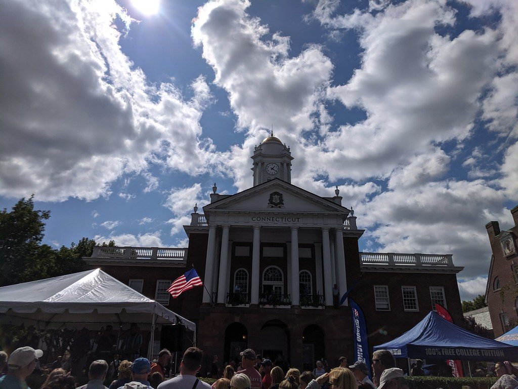 The columned brick Connecticut state building on the Avenue of the States, with fair tents and crowds in front