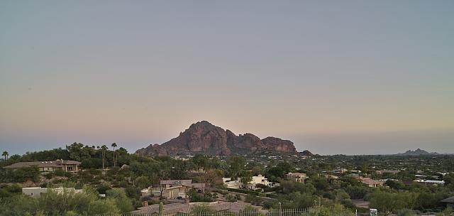 Camelback Mountain at dusk, viewed over palm trees in Scottsdale, Arizona