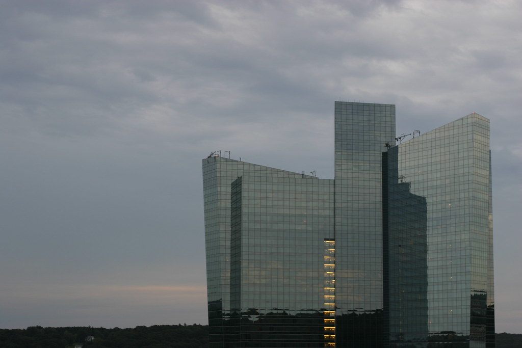 The curved glass Sky Tower at Mohegan Sun under a grey evening sky