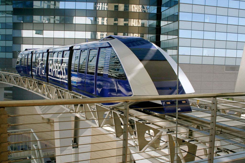 A blue Aria Express tram car on its elevated track between CityCenter buildings