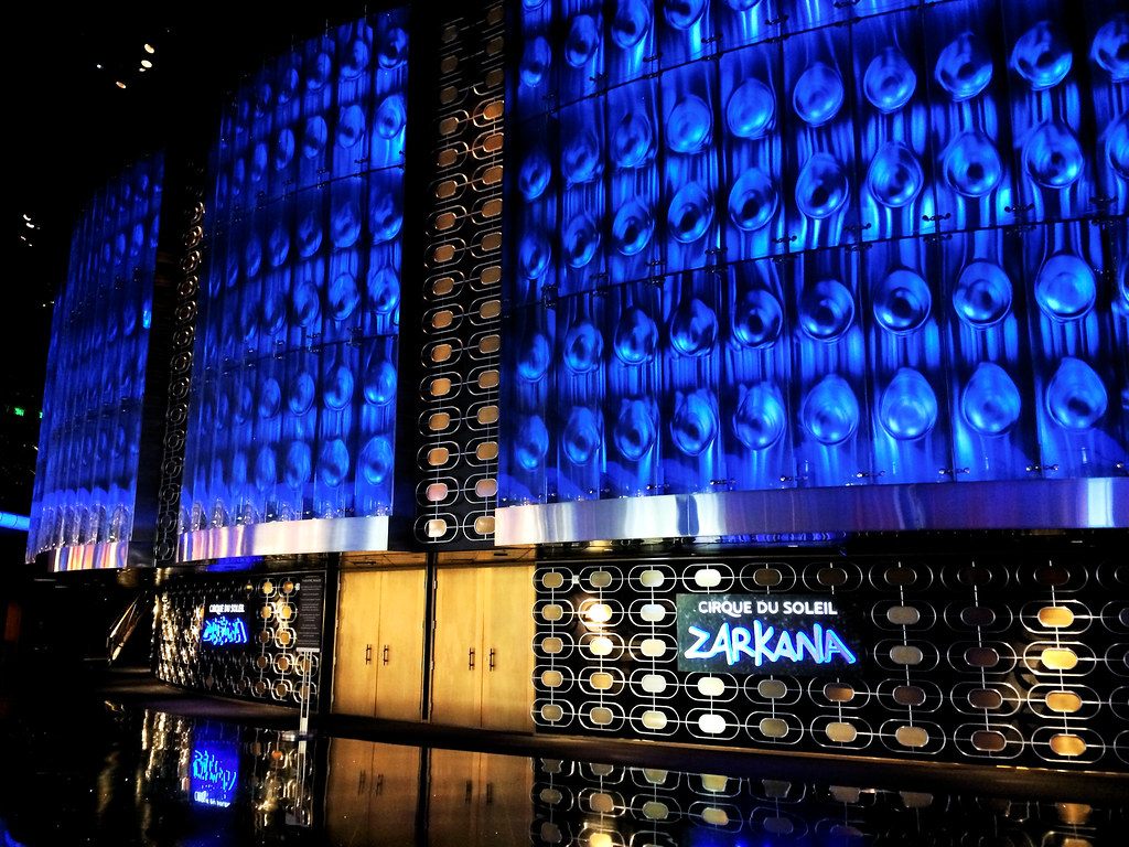 The blue-lit curved facade of the Zarkana theater at ARIA, with the Cirque du Soleil Zarkana sign above the doors