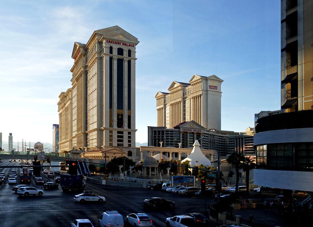 Caesars Palace hotel towers above Las Vegas Boulevard, with traffic on the Strip in the foreground