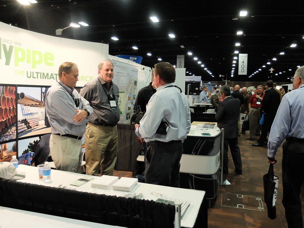 Exhibitors talking in a carpeted aisle of booths at the GEA Geothermal Expo at MGM Grand
