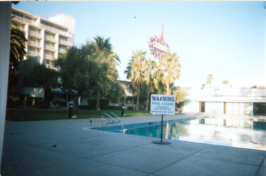 The closed pool at the Stardust in 2006, with a low-rise hotel wing and the Stardust sign behind the palms