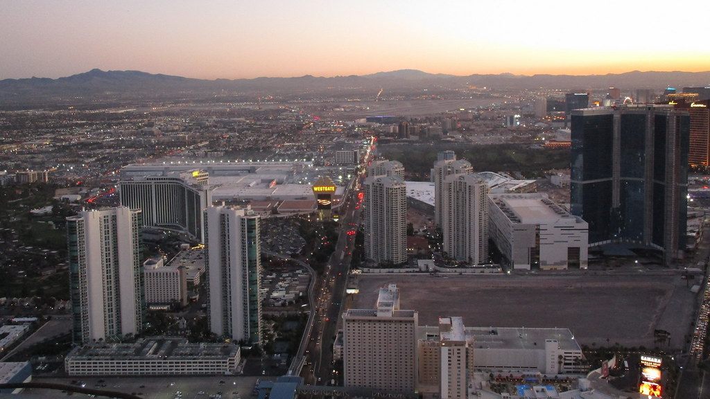 Dusk view over Paradise Road, with the lit Westgate sign and tower and the long low roofs of the Las Vegas Convention Center behind