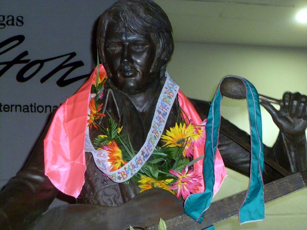 A bronze Elvis Presley statue draped with flowers and birthday ribbons at the Las Vegas Hilton