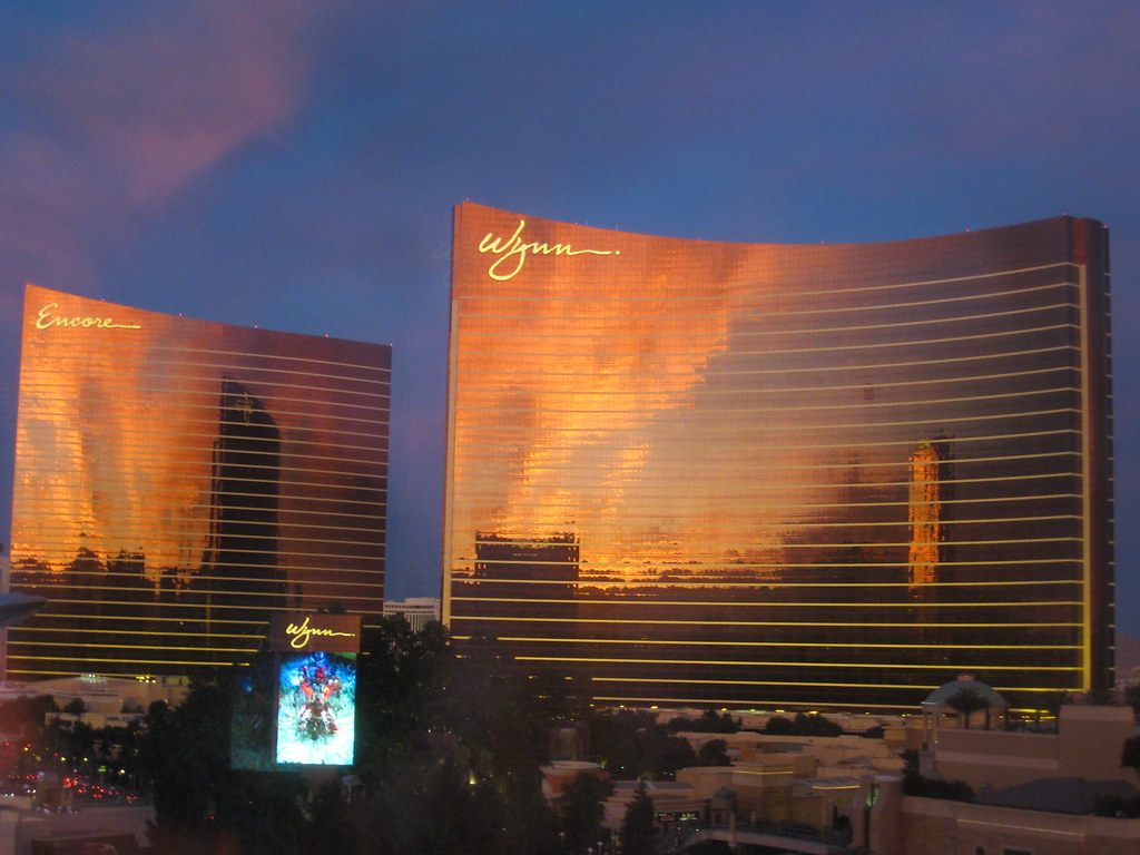 The Encore and Wynn towers glowing orange at sunset, with the Wynn marquee in front