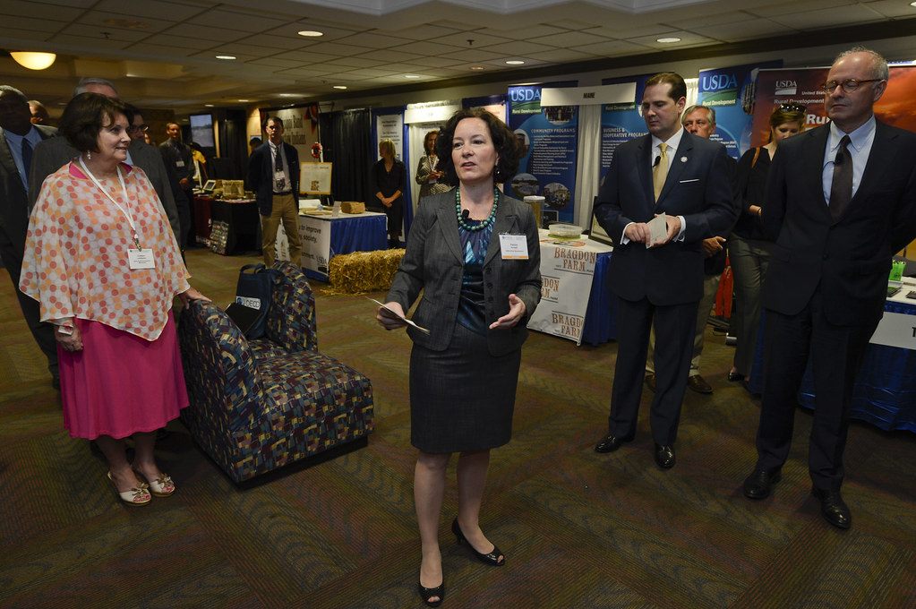Tabletop exhibits and attendees on patterned carpet under a low ceiling at the Memphis Cook Convention Center in 2015, before the renovation