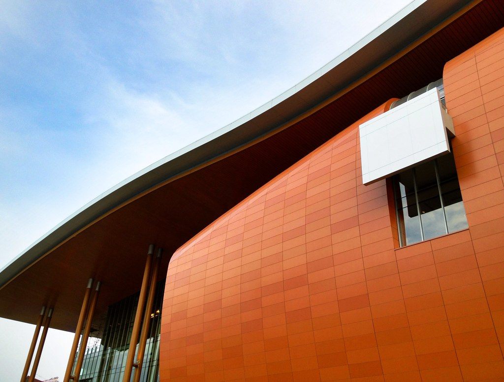 The curved roof edge and terracotta-colored wall of the Music City Center