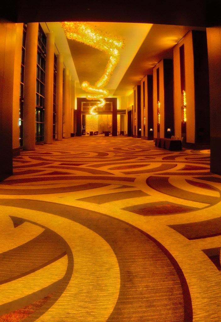 A prefunction corridor at the Omni Nashville Hotel with patterned carpet and warm lighting