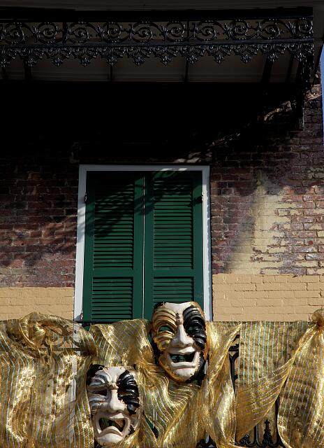 Mardi Gras comedy and tragedy masks on a wrought-iron French Quarter balcony in New Orleans