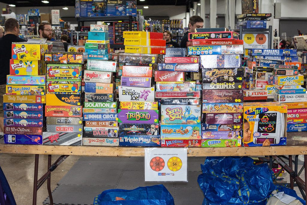 A vendor table stacked high with vintage board games, Scrabble to Yahtzee, on the Retro Con show floor at the Greater Philadelphia Expo Center