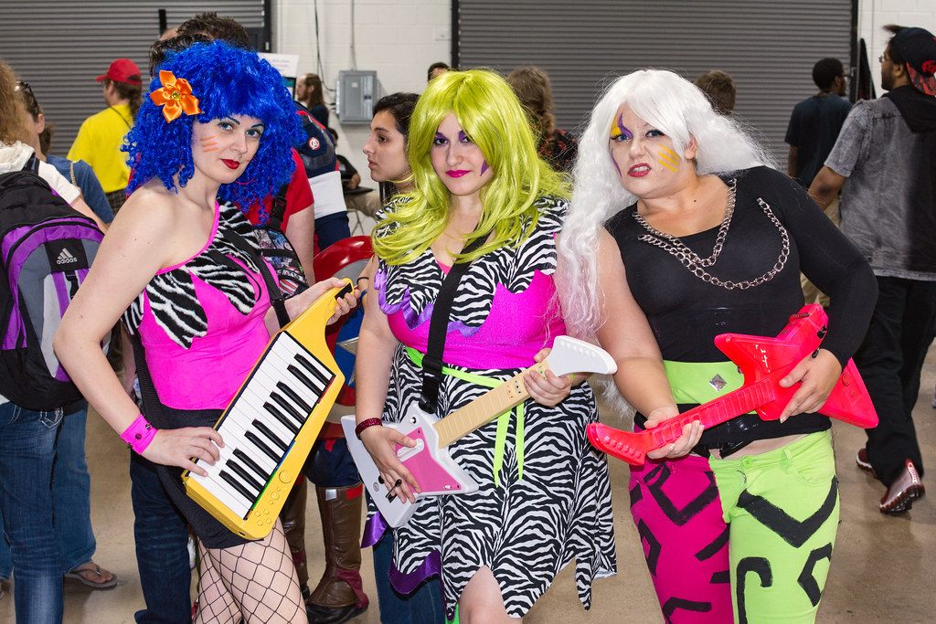 Costumed attendees on the show floor at Retro Con in Oaks, with the hall's overhead doors behind them