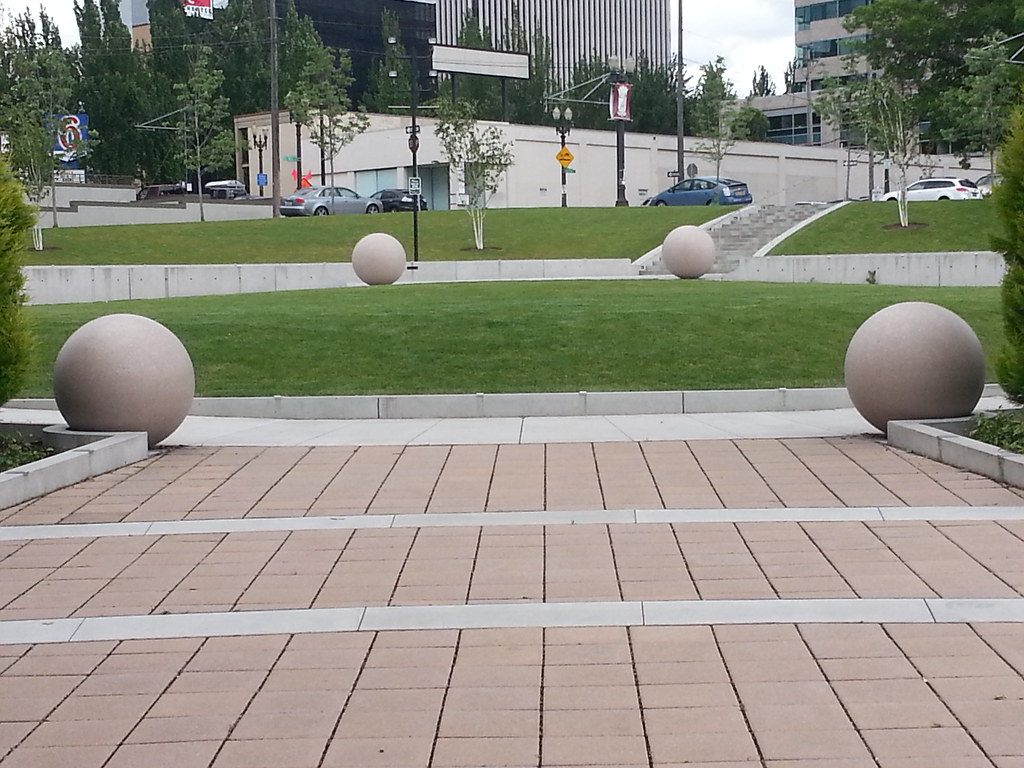 Stone spheres on a lawn and paved walkway in the Oregon Convention Center plaza