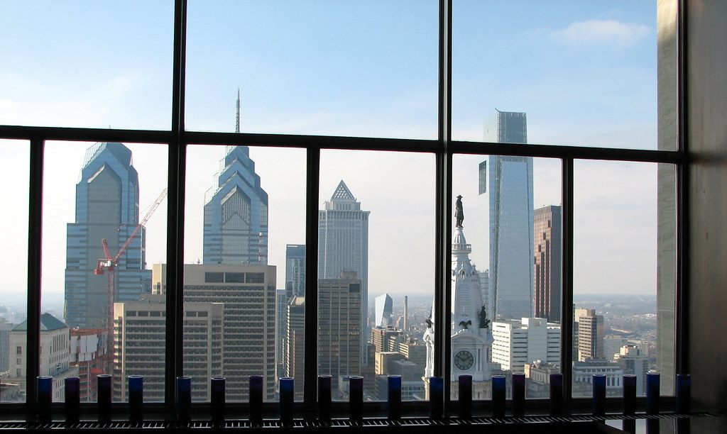 Center City skyscrapers and the William Penn statue atop City Hall seen through tall windows on the 32nd floor of the Loews hotel at 12th and Market