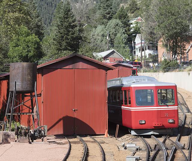 A red train car of the Pikes Peak Cog Railway at its Manitou Springs base station, Colorado