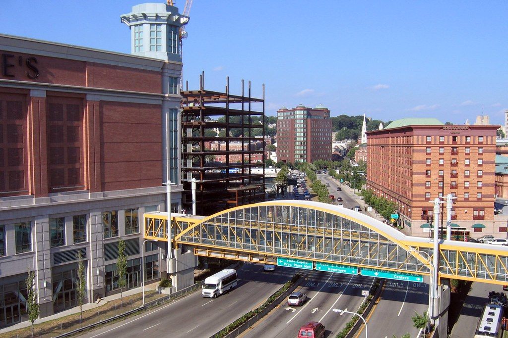 The arched glass Providence Skybridge crossing a multi-lane downtown road, seen from the convention center parking garage