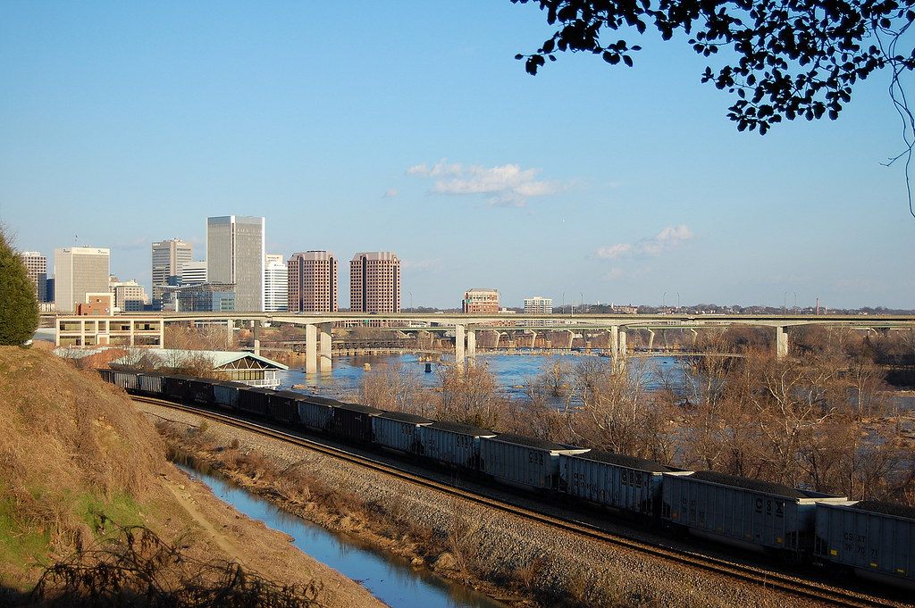 Downtown Richmond's towers and the James River bridges, with a coal train running along the riverbank below