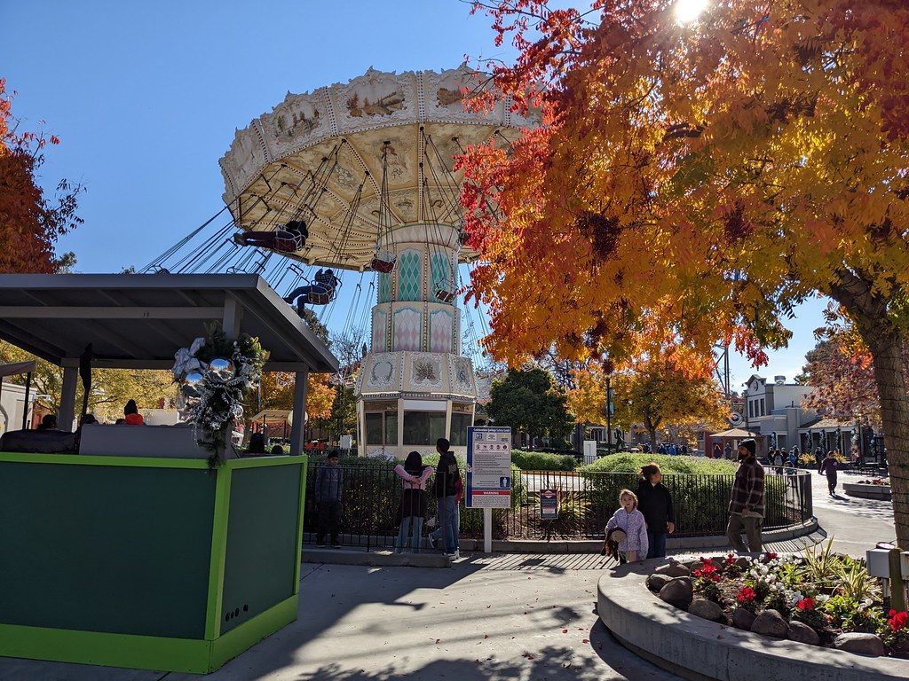 A swing carousel ride under autumn trees at California's Great America amusement park in Santa Clara