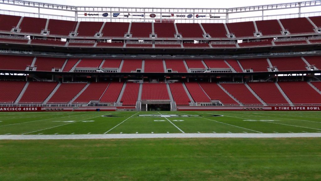 The empty red seating bowl and green field of Levi's Stadium in Santa Clara