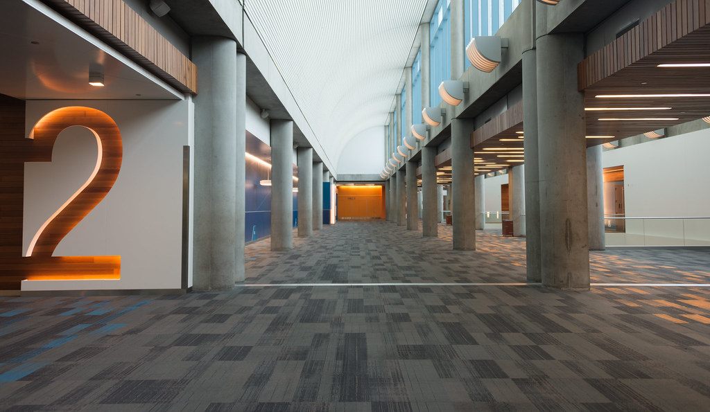 An empty, carpeted concourse at the San Jose convention center with a giant illuminated number 2 marking the Hall 2 entrance