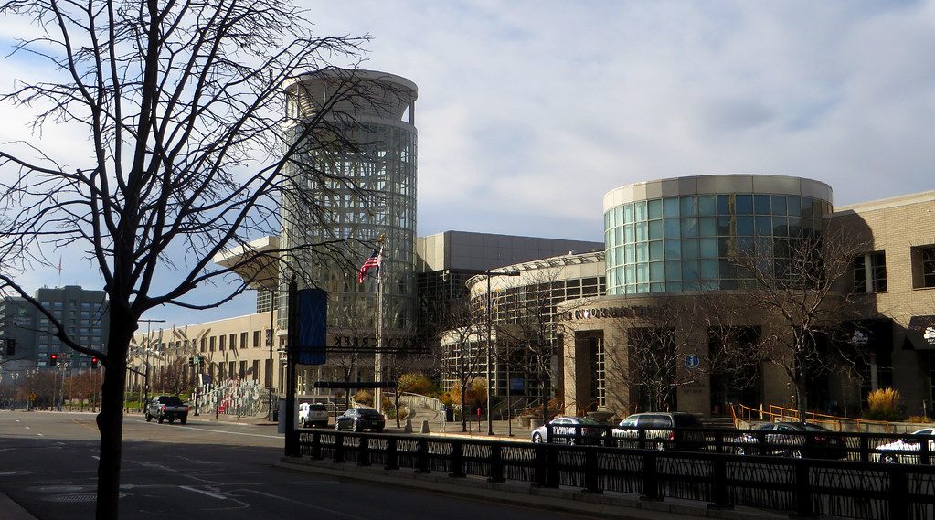 The long Salt Palace frontage on a downtown street, with the glass tower at one end and a rotunda at the other