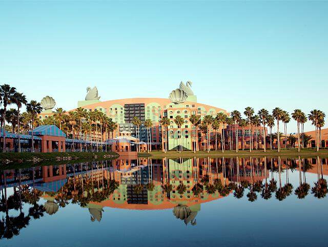 The Walt Disney World Swan and Dolphin hotel with its rooftop sculptures beside a lake