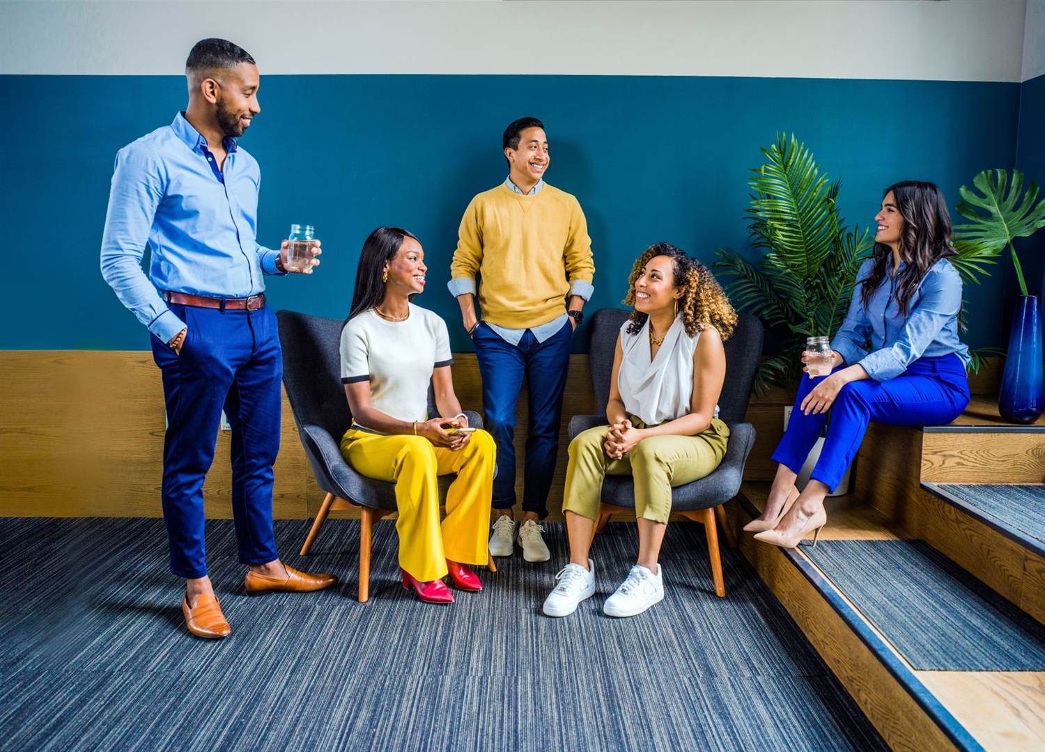 Five colleagues talking and laughing in a lounge