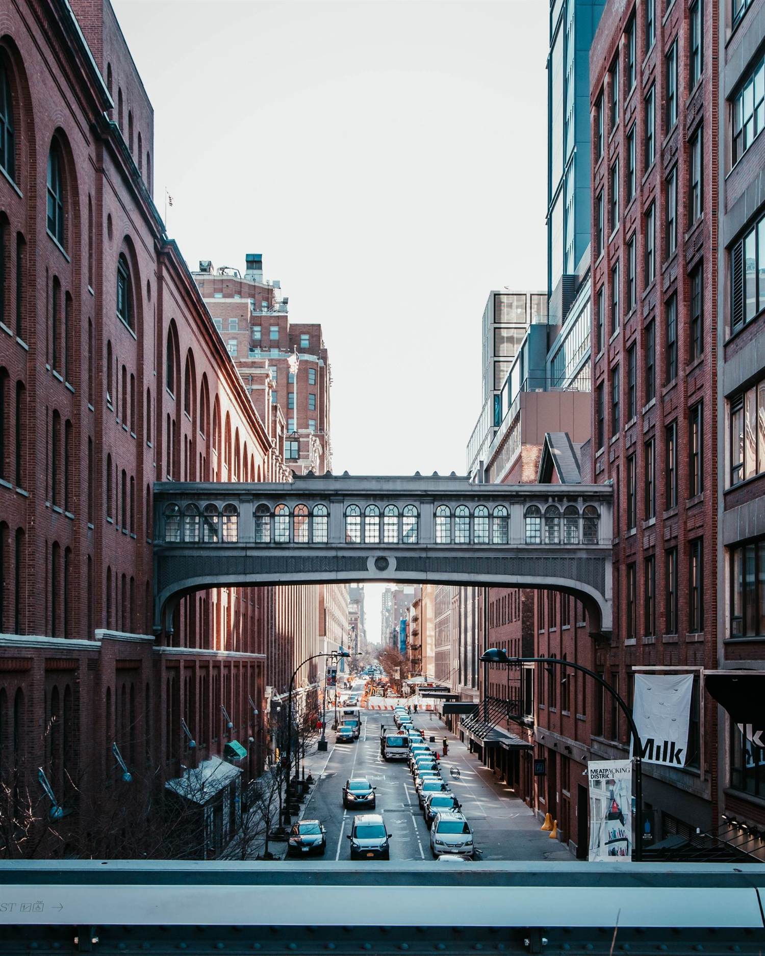 A Manhattan street seen beneath a historic bridge structure