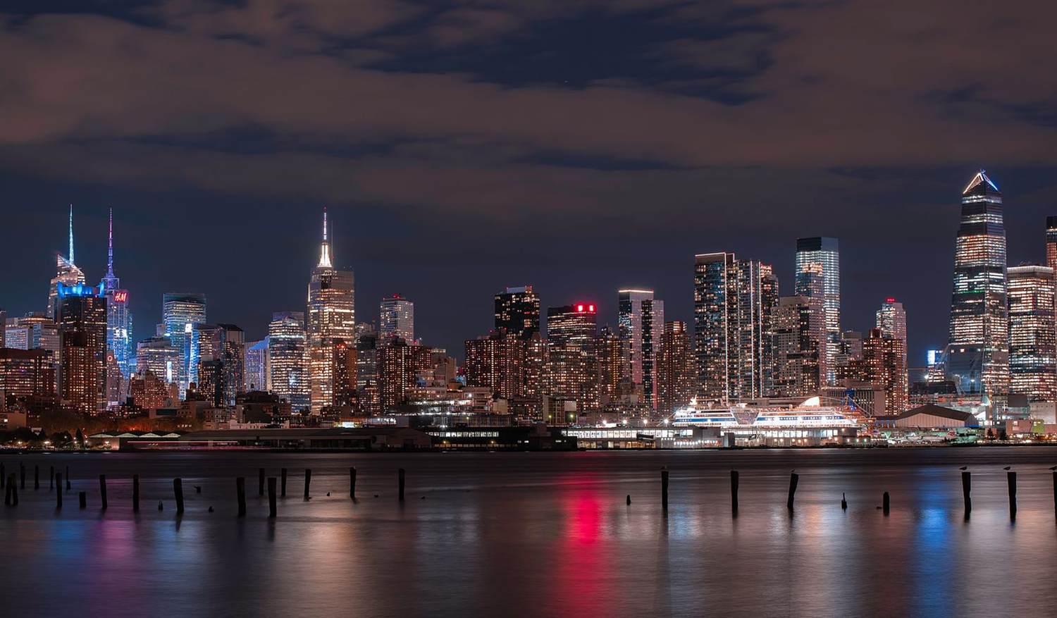 The New York City skyline at night reflected in the water