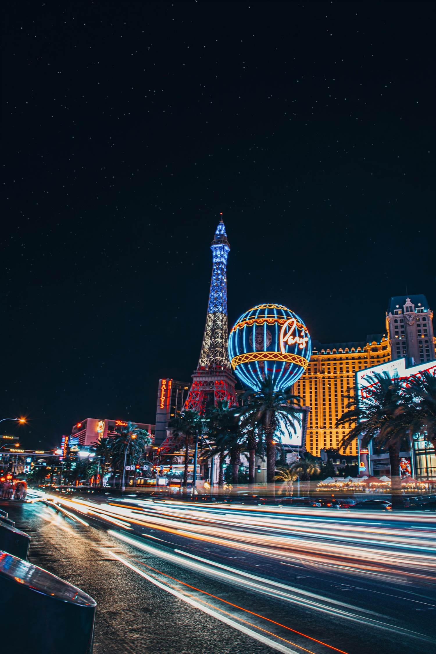 Paris Las Vegas Eiffel Tower and balloon at night with car light trails on the Strip