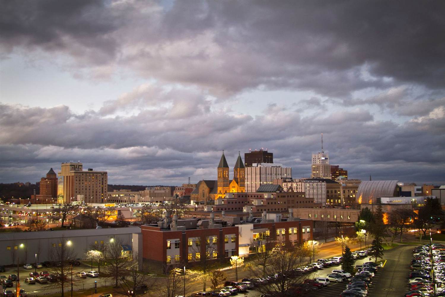 Downtown Akron, Ohio at dusk under a dramatic cloudy sky