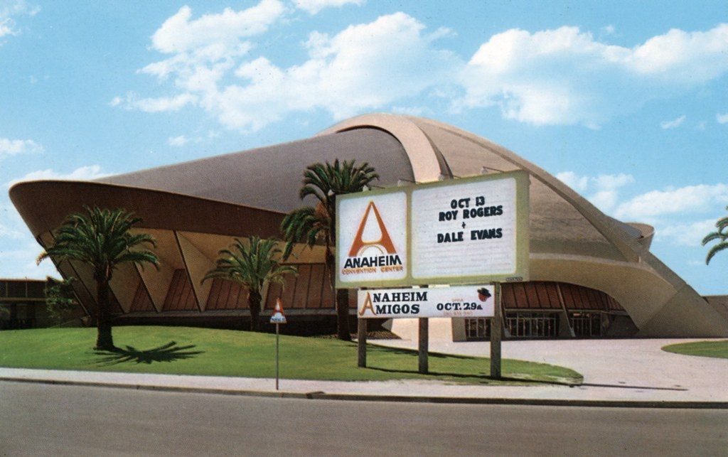 Vintage color view of the Anaheim Convention Center's domed Arena behind palm trees and a roadside marquee sign