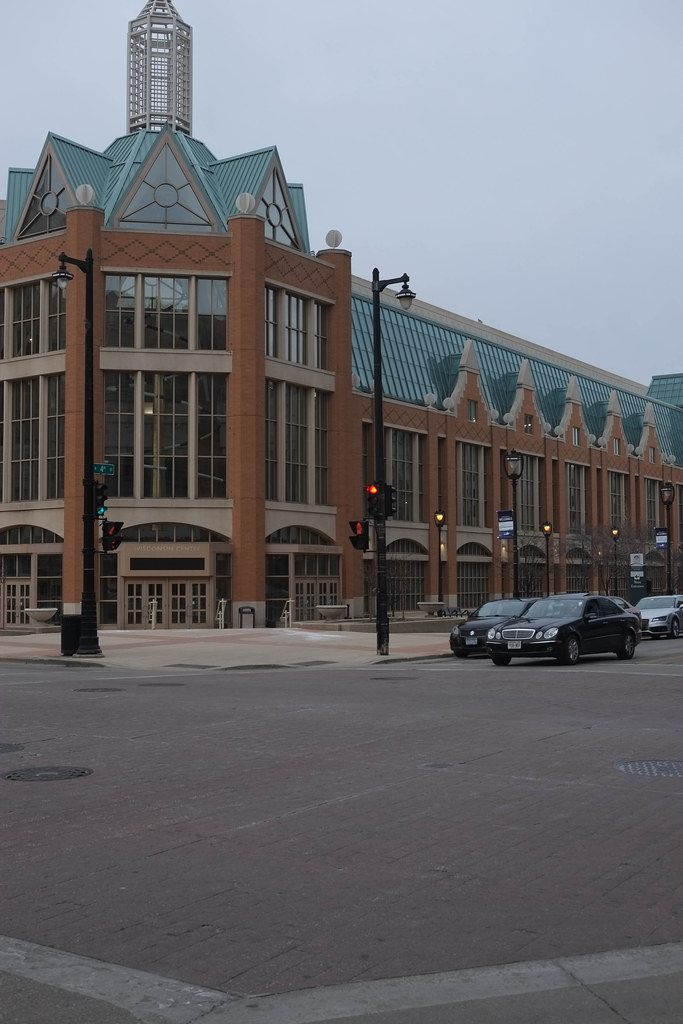 The brick and green-glass corner of the original 1998 building at 4th Street and Wisconsin Avenue in 2016, with Wisconsin Center lettering over the entrance doors