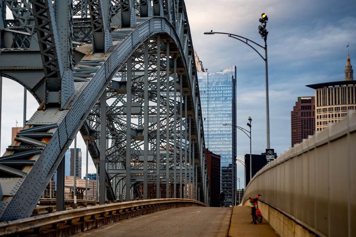 A steel arch bridge in downtown Cleveland, Ohio with the Huntington Bank tower visible