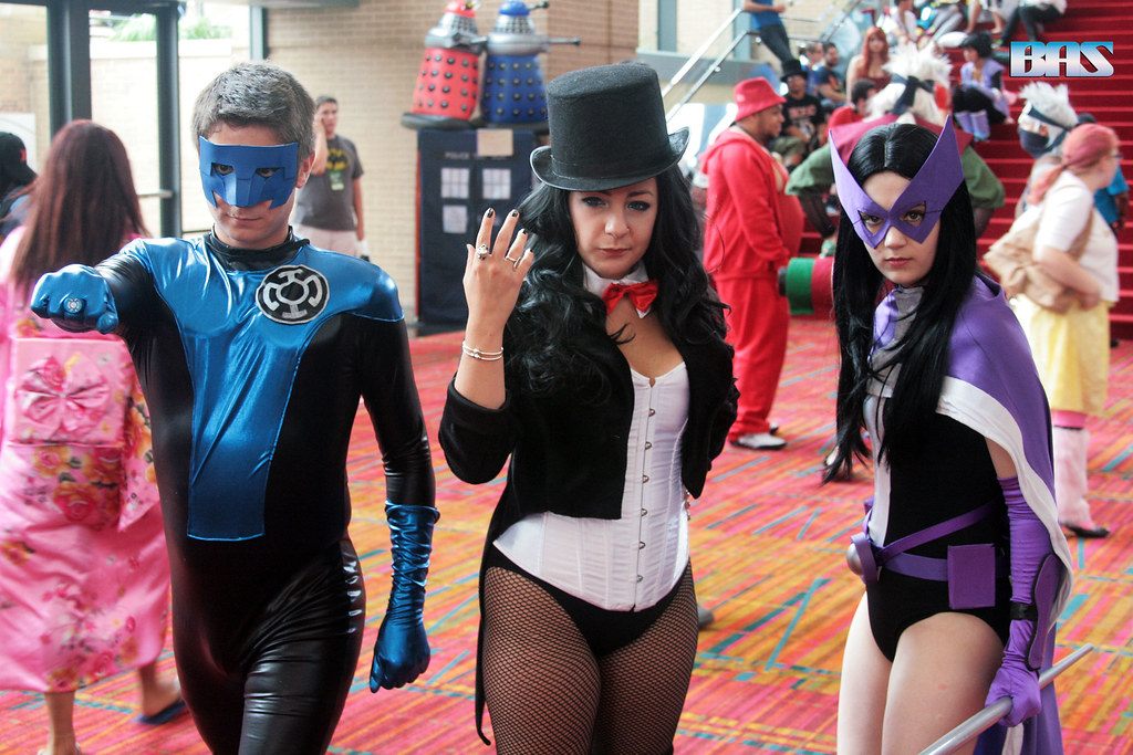 Cosplayers dressed as DC heroes striding through a busy hall at ConnectiCon 2013 in Hartford